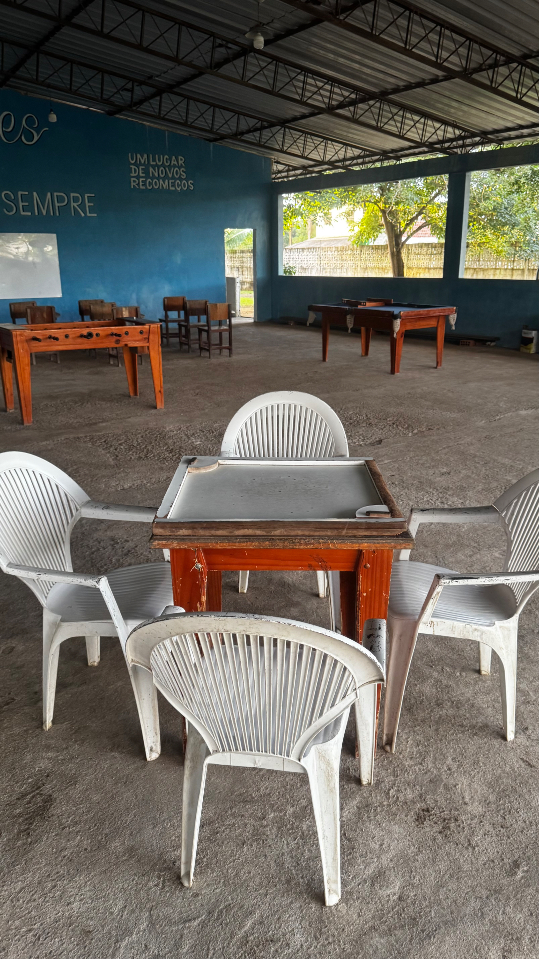 Salão de jogos com mesa de sinuca, totó e mesa de jogos